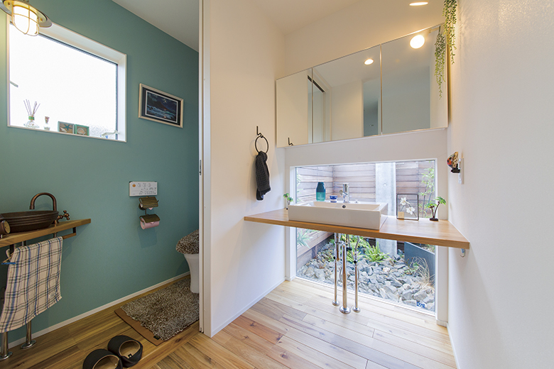 爽やかなアクセントカラーのトイレと造作洗面台 ブルーグリーンのアクセントウォール