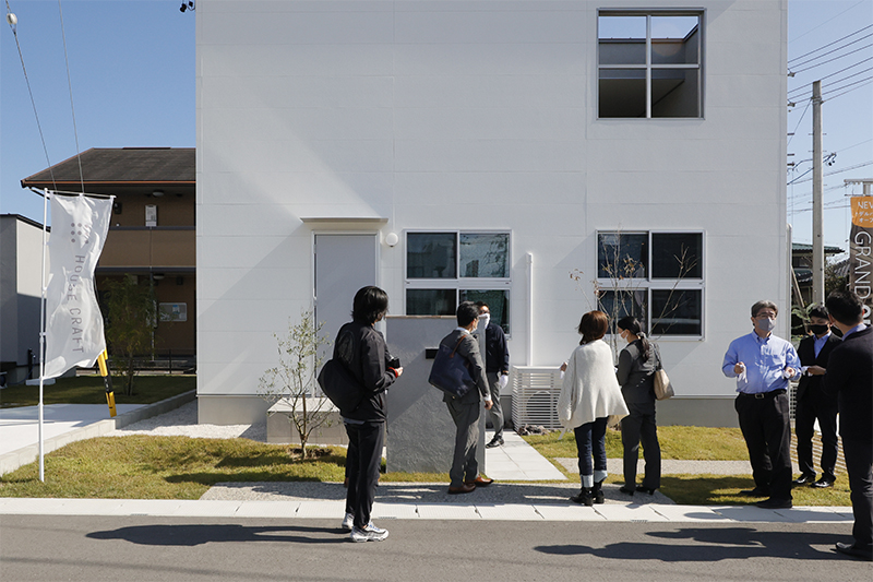 白い家を見学するたくさんの人