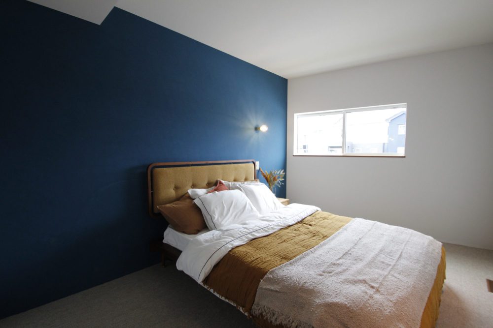 ブルーのアクセントウォールが映えるミッドセンチュリースタイルの寝室