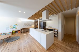 天然木の床に真っ白なオープンキッチン
